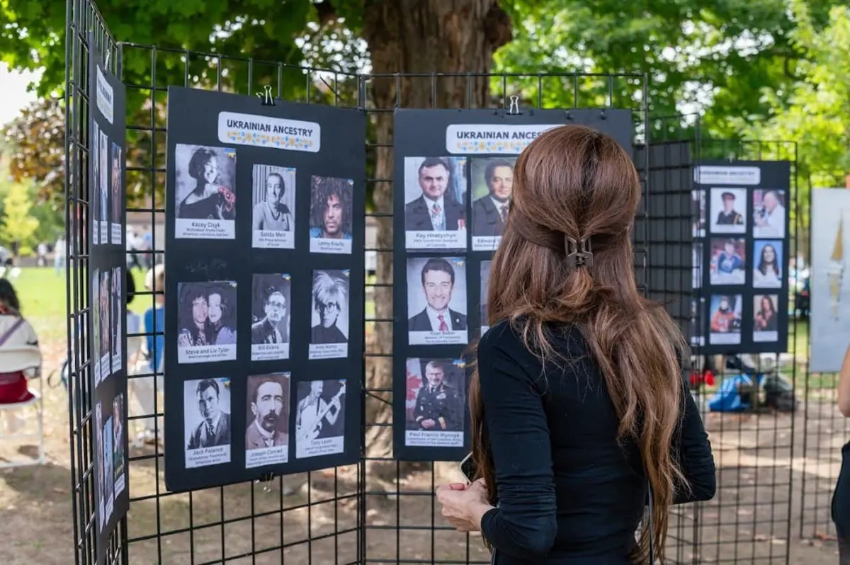 Informational display boards with photos and text about Ukrainian history mounted along a fence at a UAFest exhibit