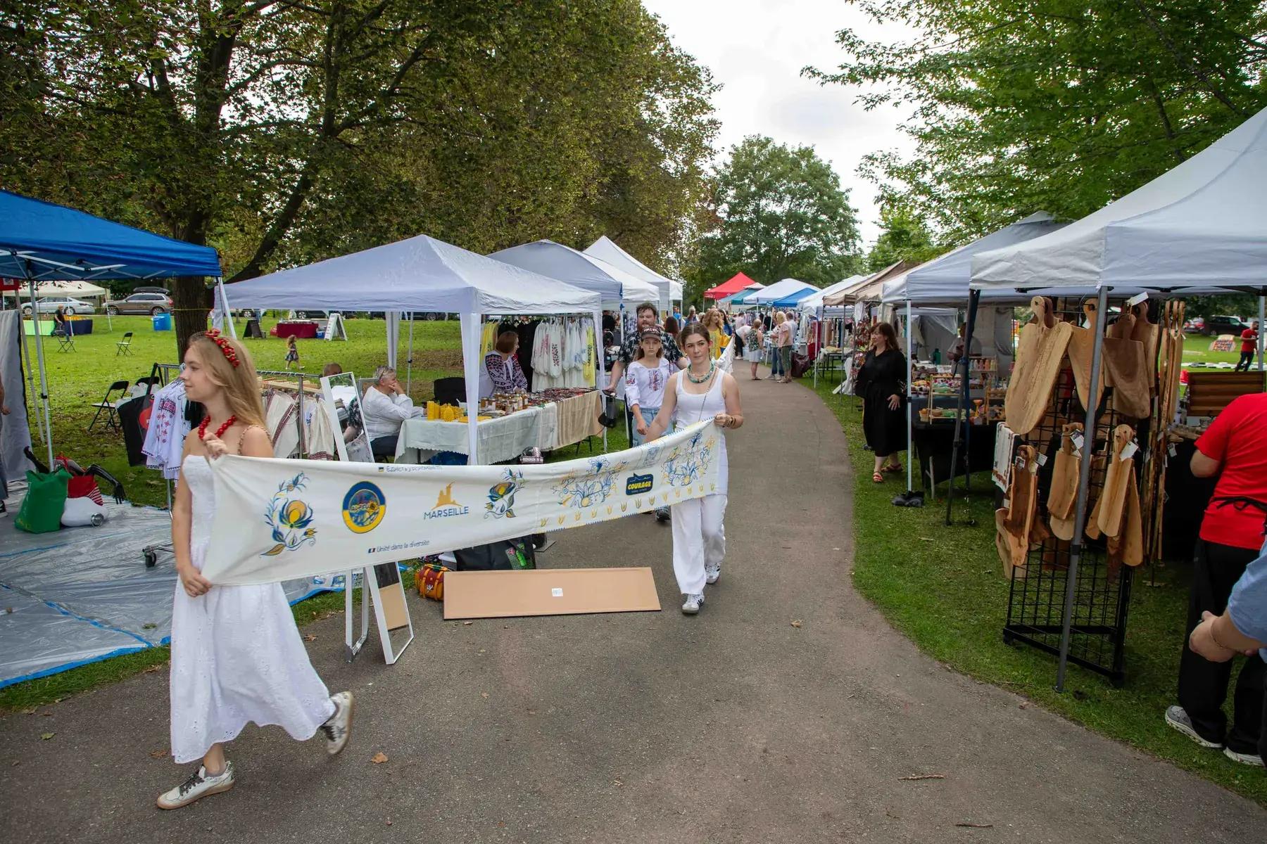 The rushnyk arrives between the market tents in Riverside Park