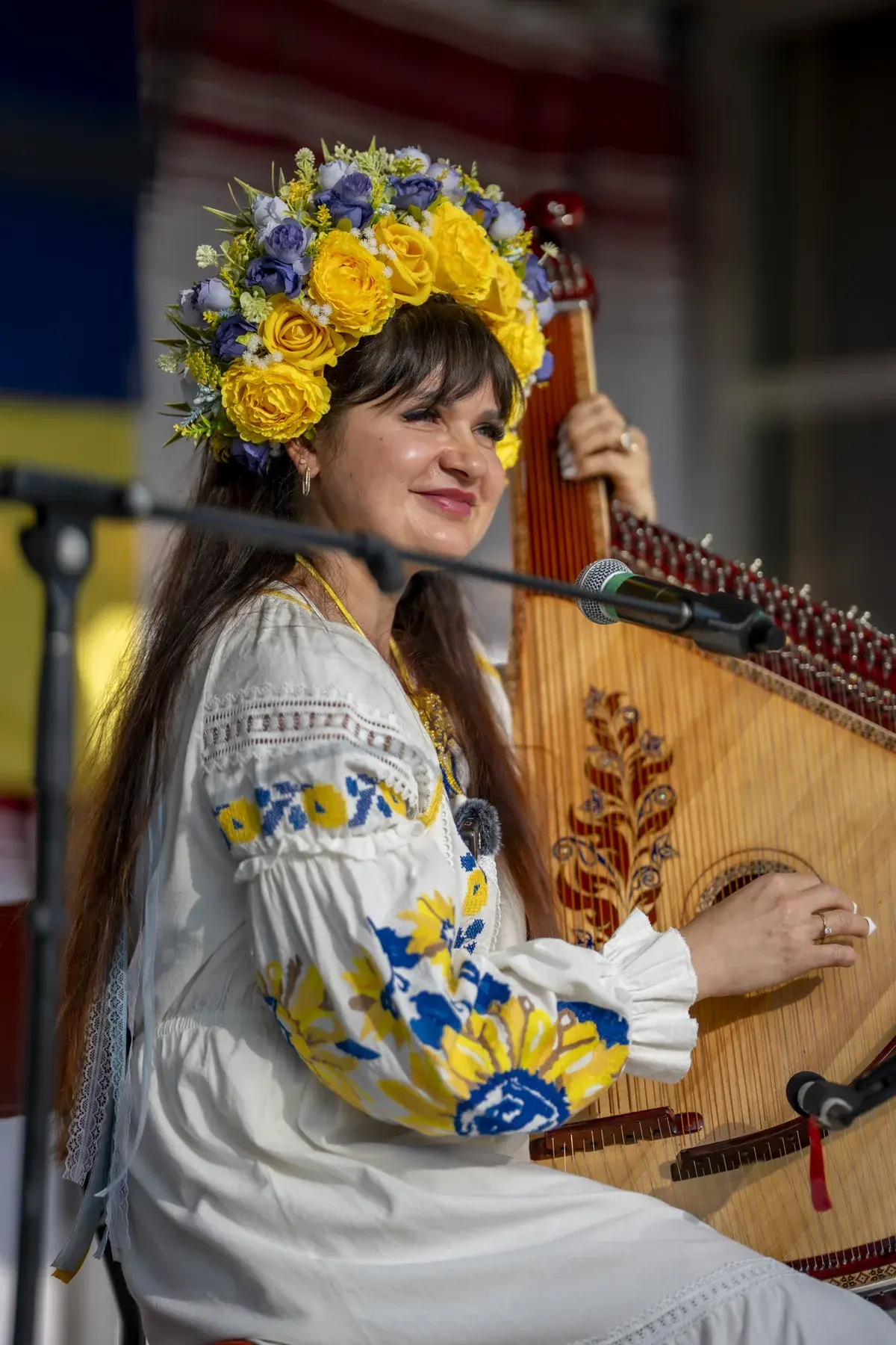 Lidiia Hurinenko at UAFest 2026 — Bandura player in a flower crown performing, smiling toward the audience (photo: Tim Skinner)