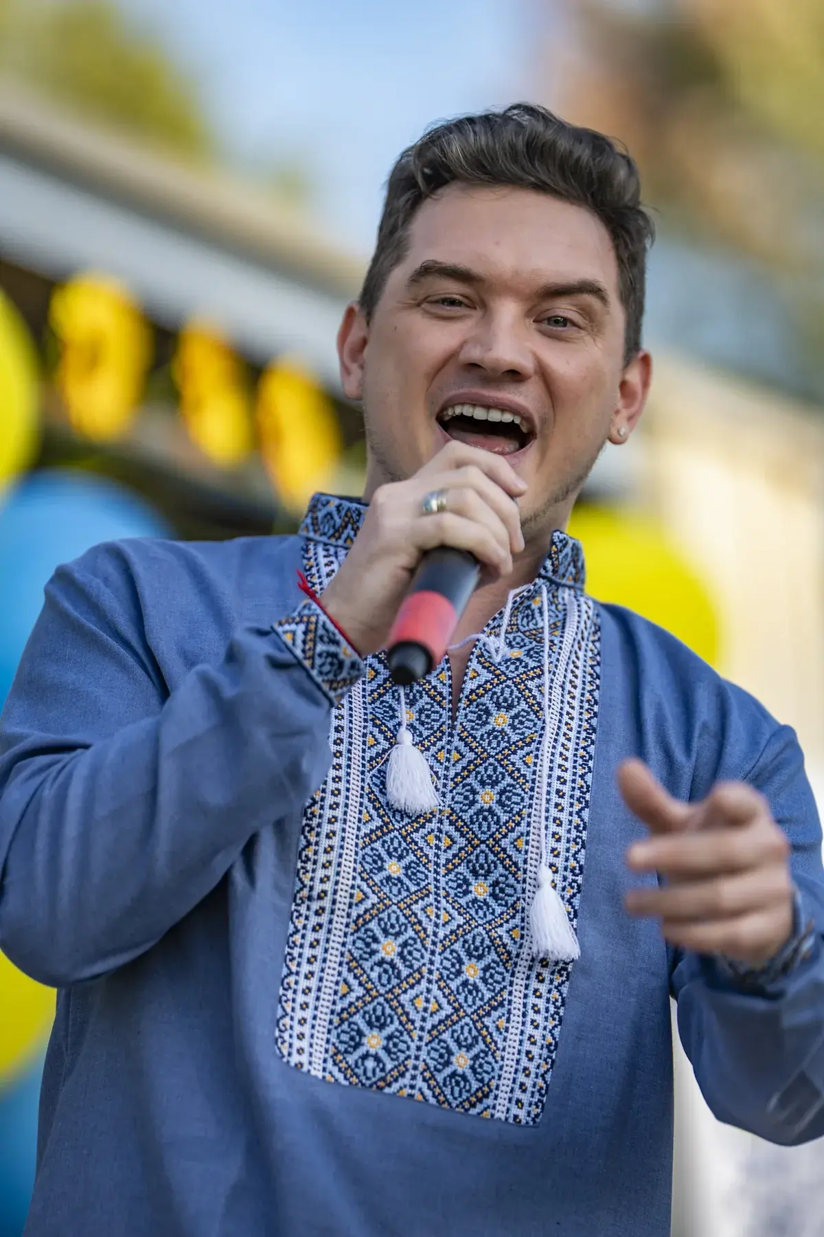 DEN BAURIN at UAFest 2026 — Male singer in a blue vyshyvanka sings and gestures to the audience (photo: Tim Skinner)