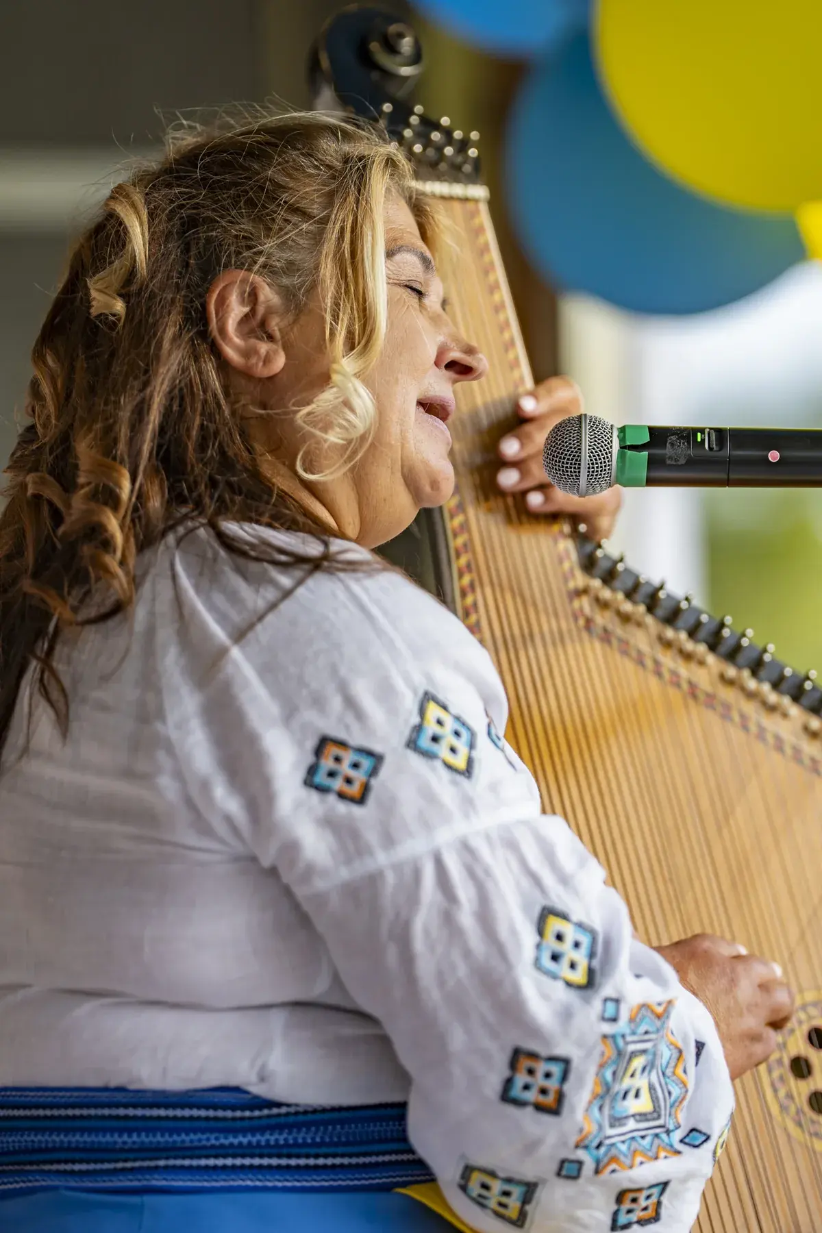 Tanya Navolska at UAFest 2026 — Bandura player in an embroidered blouse sings with eyes closed, close view (photo: Tim Skinner)
