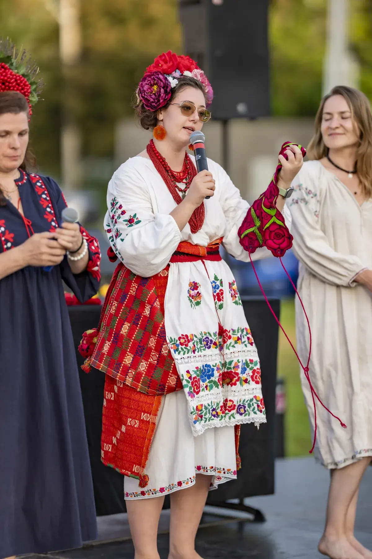 Oksana Pikush at UAFest 2026 — Host with a microphone holds up an embroidered item during the costume show (photo: Tim Skinner)