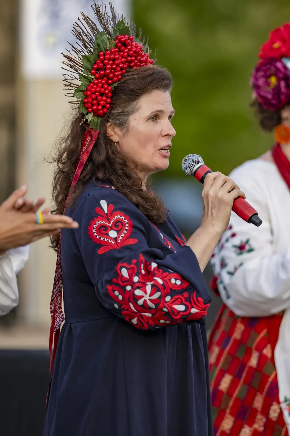 Oksana Pikush at UAFest 2026 — Woman in viburnum wreath and embroidered dress speaks into a microphone (photo: Tim Skinner)
