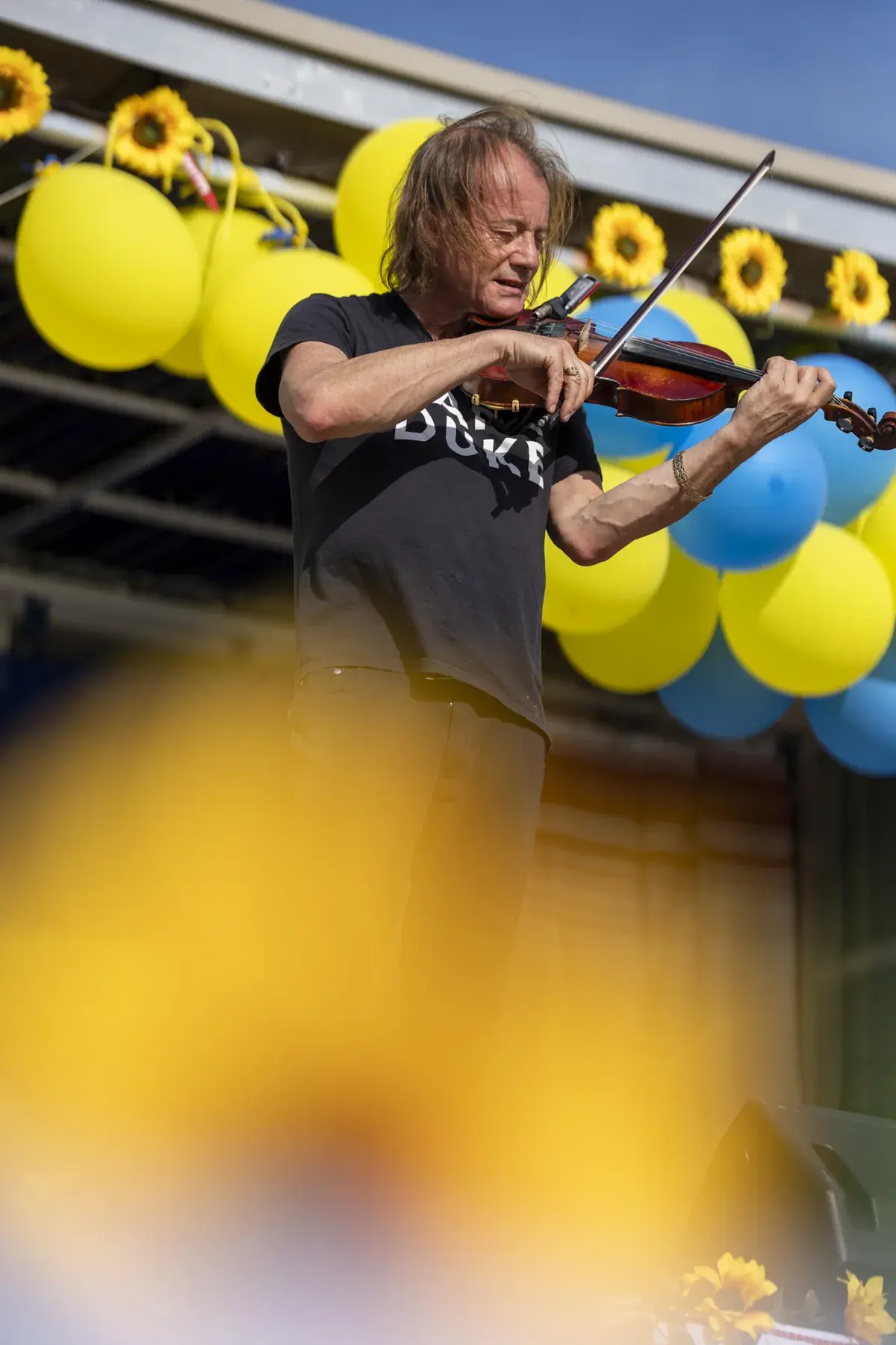 Vasyl Popadiuk at UAFest 2026 — Violinist on stage framed by a blurred sunflower in the foreground (photo: Tim Skinner)