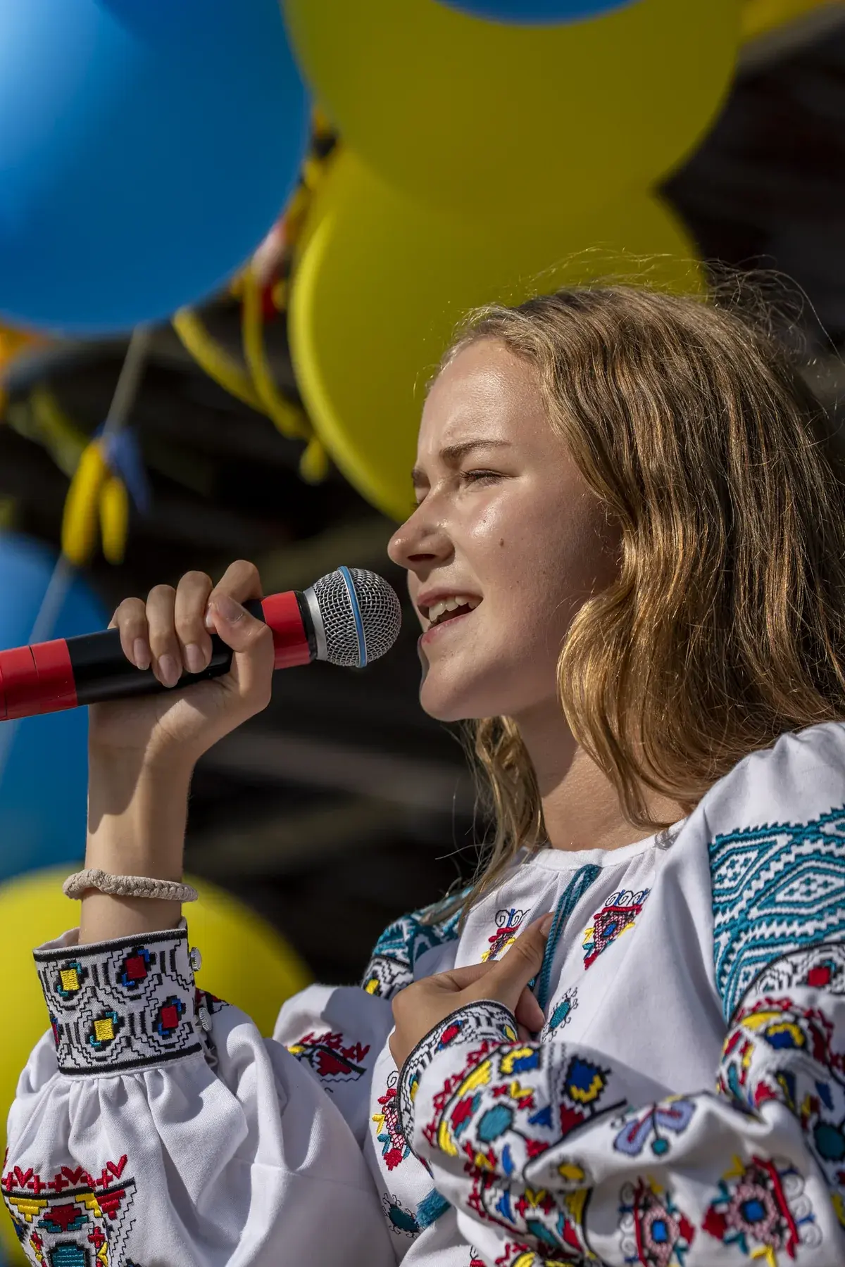 Marta Stepanenko at UAFest 2026 — Teen singer with hand on heart sings on stage (photo: Tim Skinner)