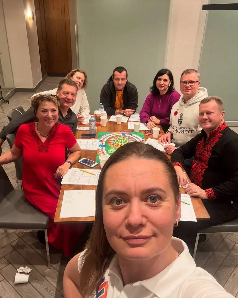 Eight UAFest organizers around a table at a planning meeting, working through printed festival plans