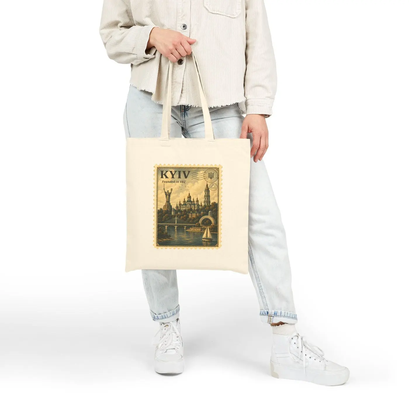 The tote carried at arm's length beside jeans and a light jacket