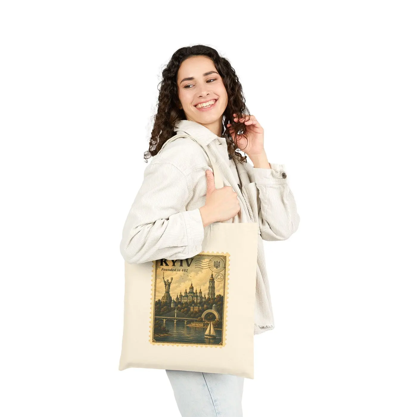 A woman carrying the Kyiv tote over her shoulder, the stamp facing out
