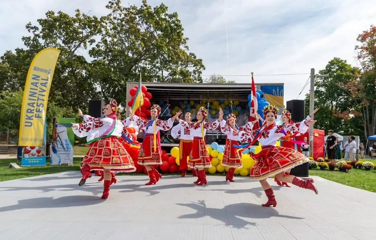 Dancers on stage with a large Ukrainian flag during the festival, with the crowd watching