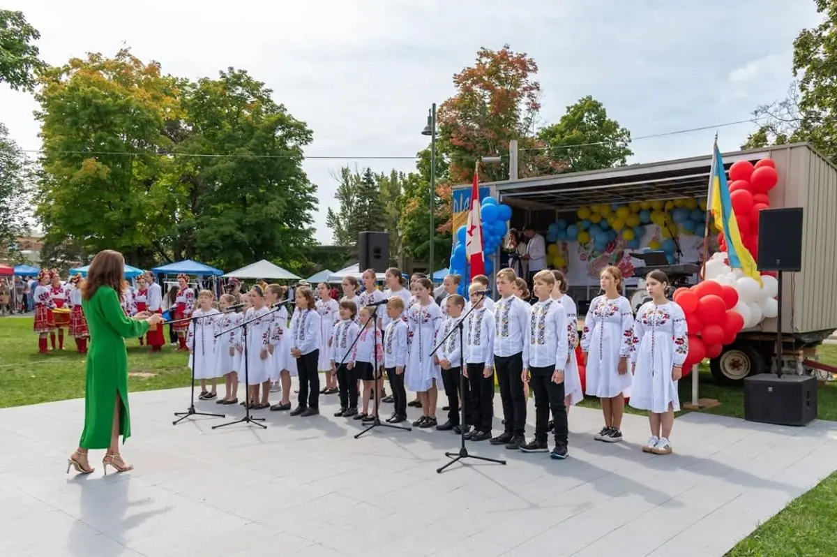 A choir in embroidered shirts singing in a circle at a past festival