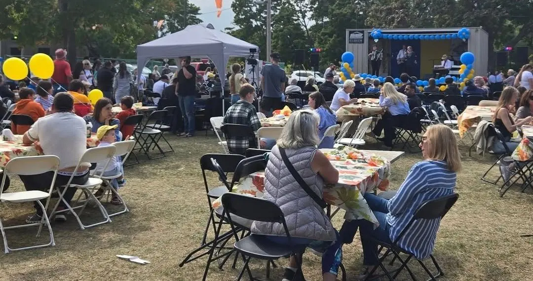 Guests relaxing at tables near the UAFest stage — the festival's hospitality corner where the day slows down