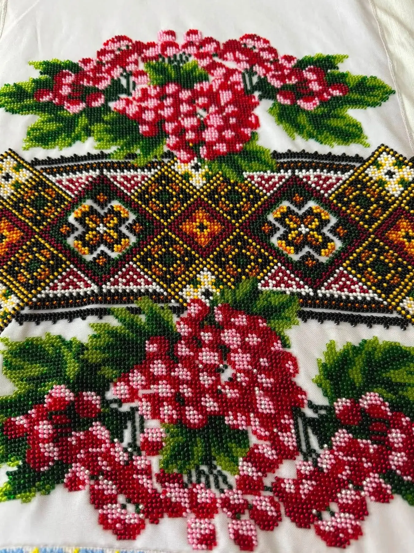 A beaded panel with kalyna berries around a geometric star