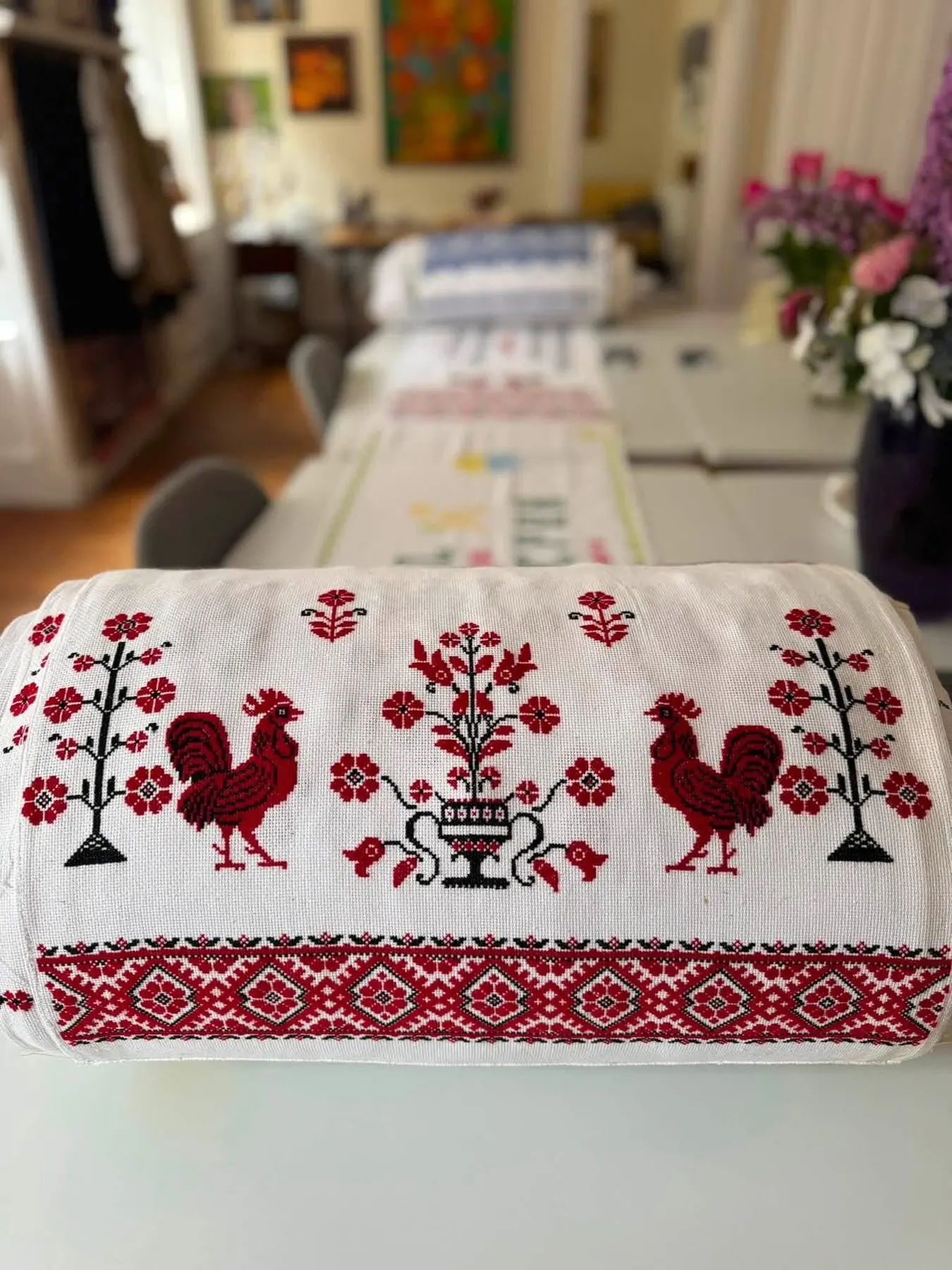 A panel embroidered with two red roosters and a tree of life