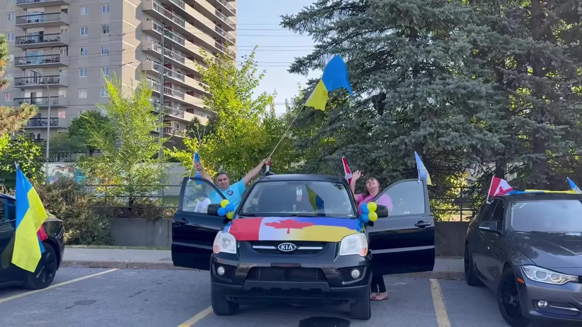 A Ukrainian flag raised over a car painted in Ukrainian and Canadian colours as the 2024 UAFest convoy gathers in Ottawa
