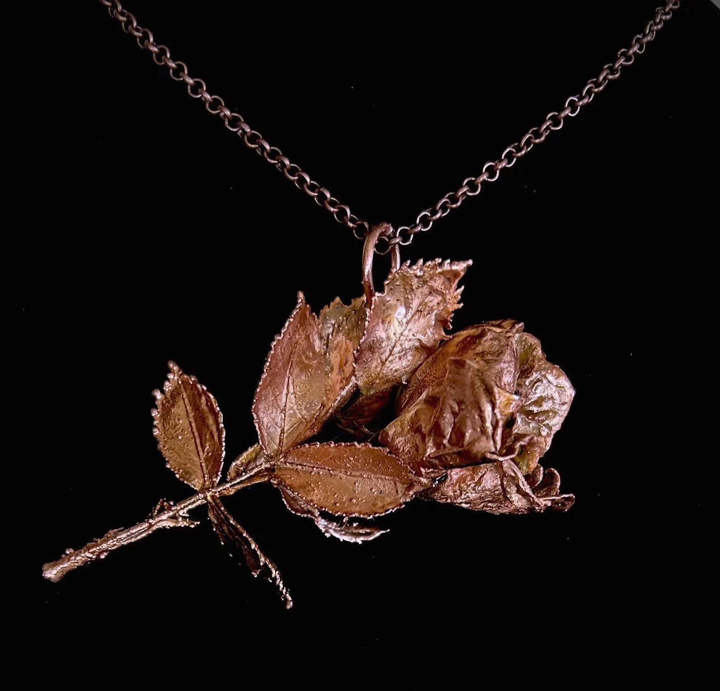 Copper rose necklace — a whole rose with stem and leaves preserved in copper on a copper chain