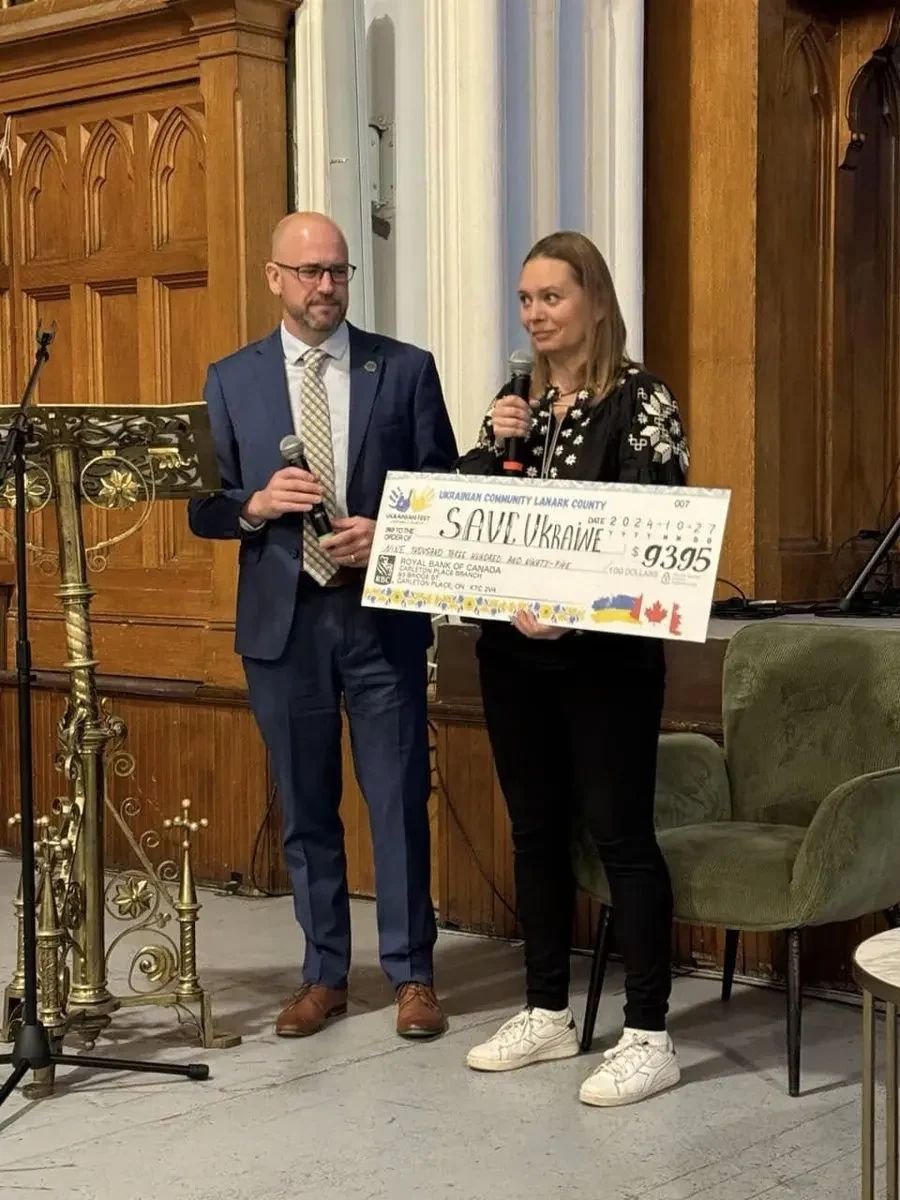 The festival's $9,395 ceremonial cheque being presented to Save Ukraine at a formal ceremony in October 2024
