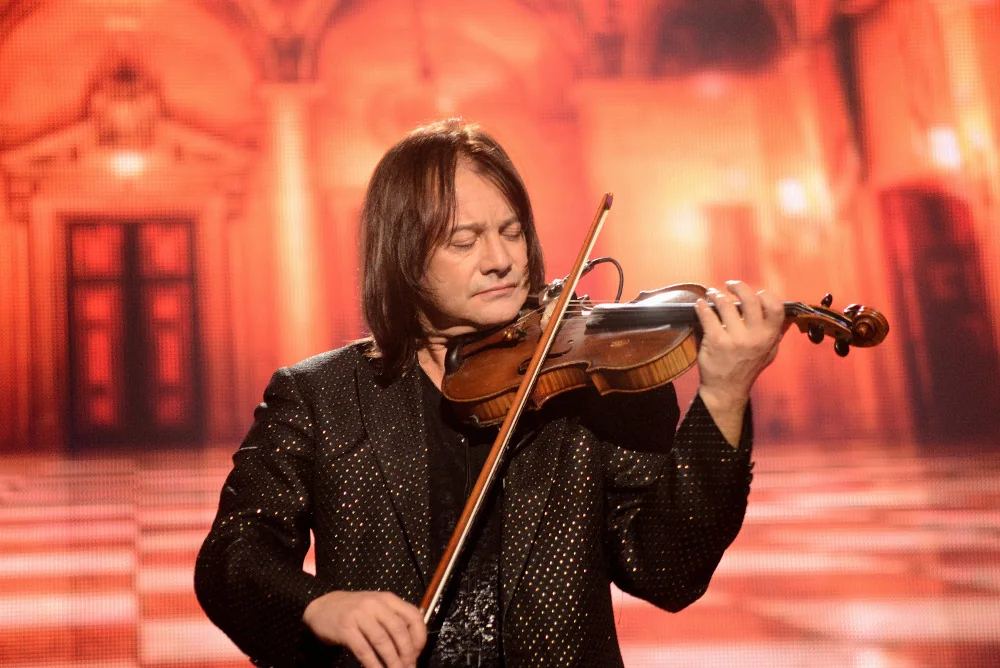 Close view of Vasyl Popadiuk bowing the violin in a sequinned black jacket
