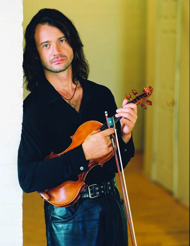 Studio portrait of Vasyl Popadiuk holding his violin and bow
