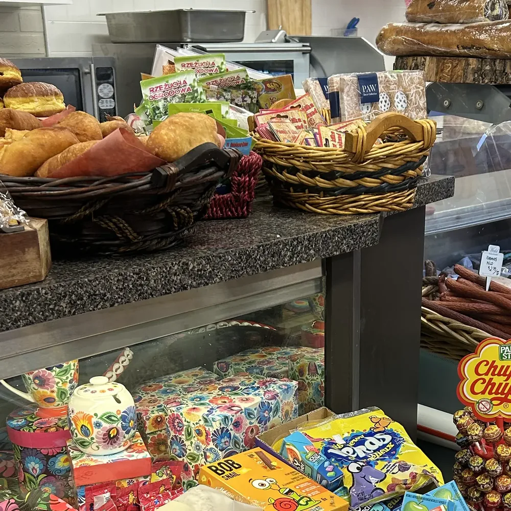 The Wedel bakery shelf — pączki, bread and pastries — beside the sausage case